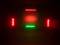 Een donkere ruimte verlicht met rode en groene LED-verlichting, gericht op een scherm, creëert een sfeervolle atmosfeer.