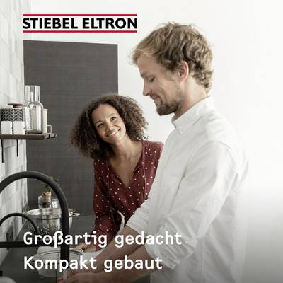 Een man en een vrouw staan naast elkaar te glimlachen in een moderne keuken. Tekst bovenaan: 'STIEBEL ELTRON', onderaan: 'Slim bedacht, Compact gebouwd'.
