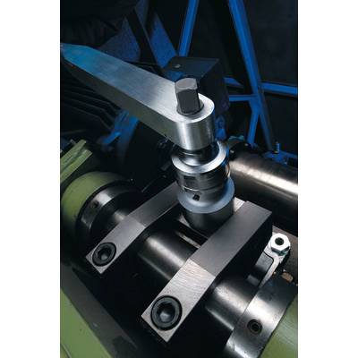 Een hefboom met schroefmechanisme op een metalen machine, omgeven door stalen componenten en gedragen door een groene houder.