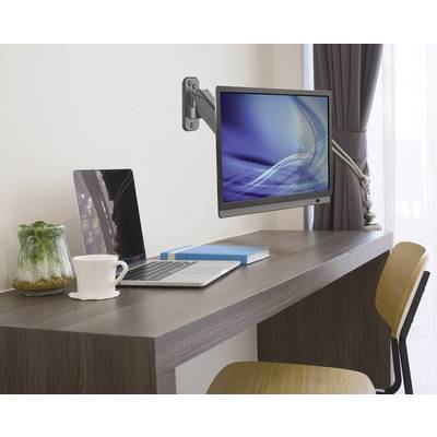 Een laptop en een monitor aan een scharnierende arm staan op een bureau. Naast hen een kopje en een glas met planten.