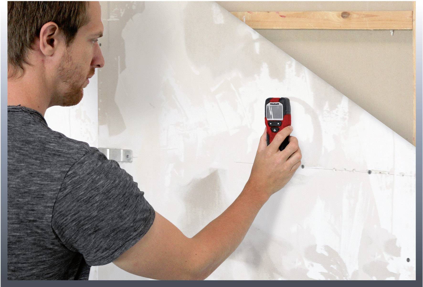 Een man meet met een elektronisch meetapparaat de dikte of dichtheid van een muur, waarschijnlijk tijdens renovatiewerkzaamheden.