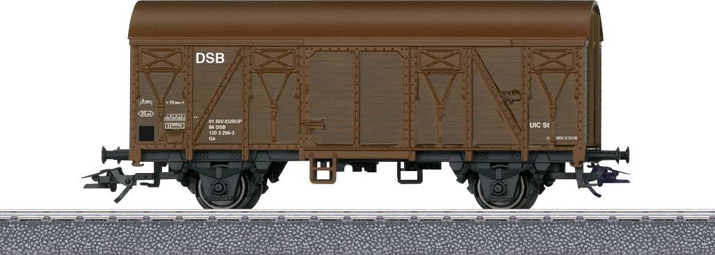 Een bruine goederenwagen van de DSB staat op een spoor. De wagen is gedetailleerd weergegeven met assen en koppelingen.