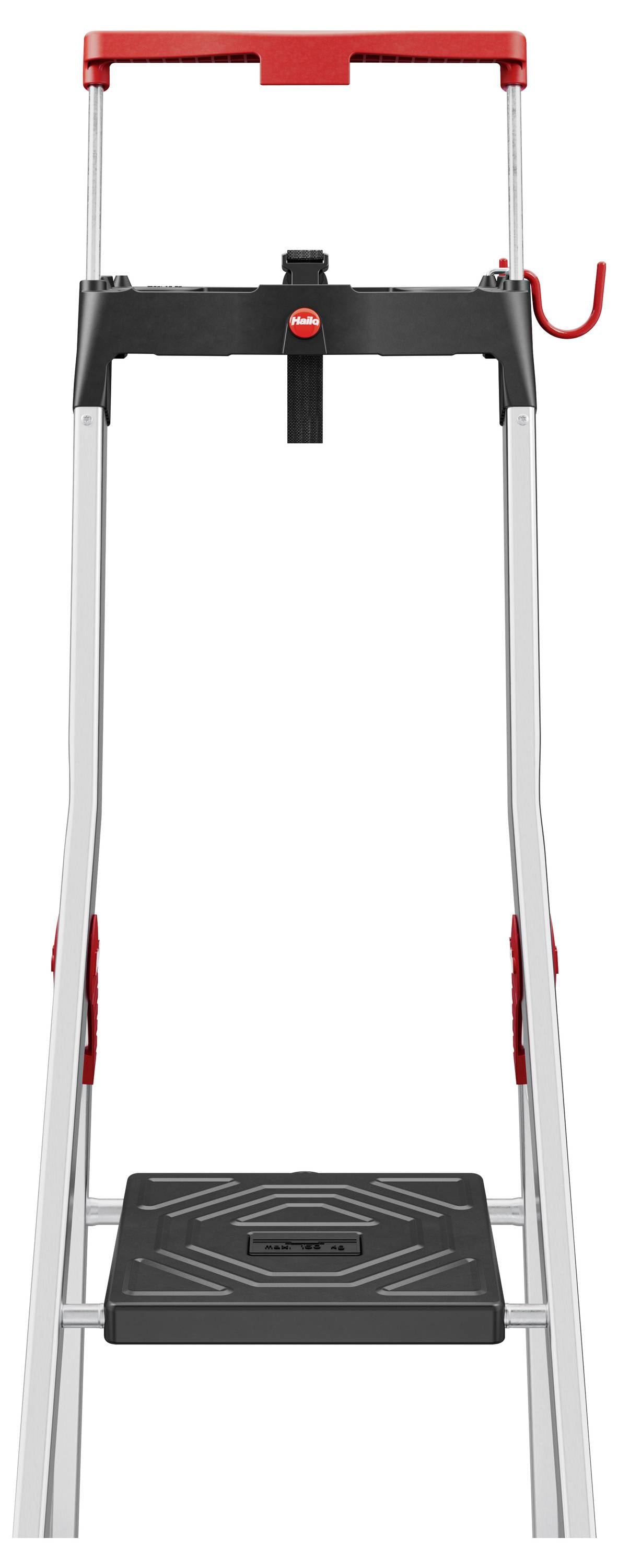 Een opvouwbare trapladder met een zwarte trede, rode bovensteuner en haak voor gereedschap, ontworpen voor gemakkelijke opslag en toegankelijkheid.