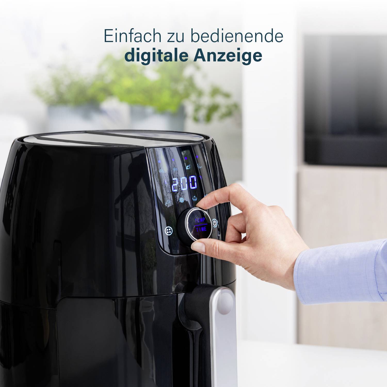 Een persoon bedient een digitaal scherm op een zwarte airfryer. Tekst bovenaan: 'Gebruiksvriendelijk digitaal display'.