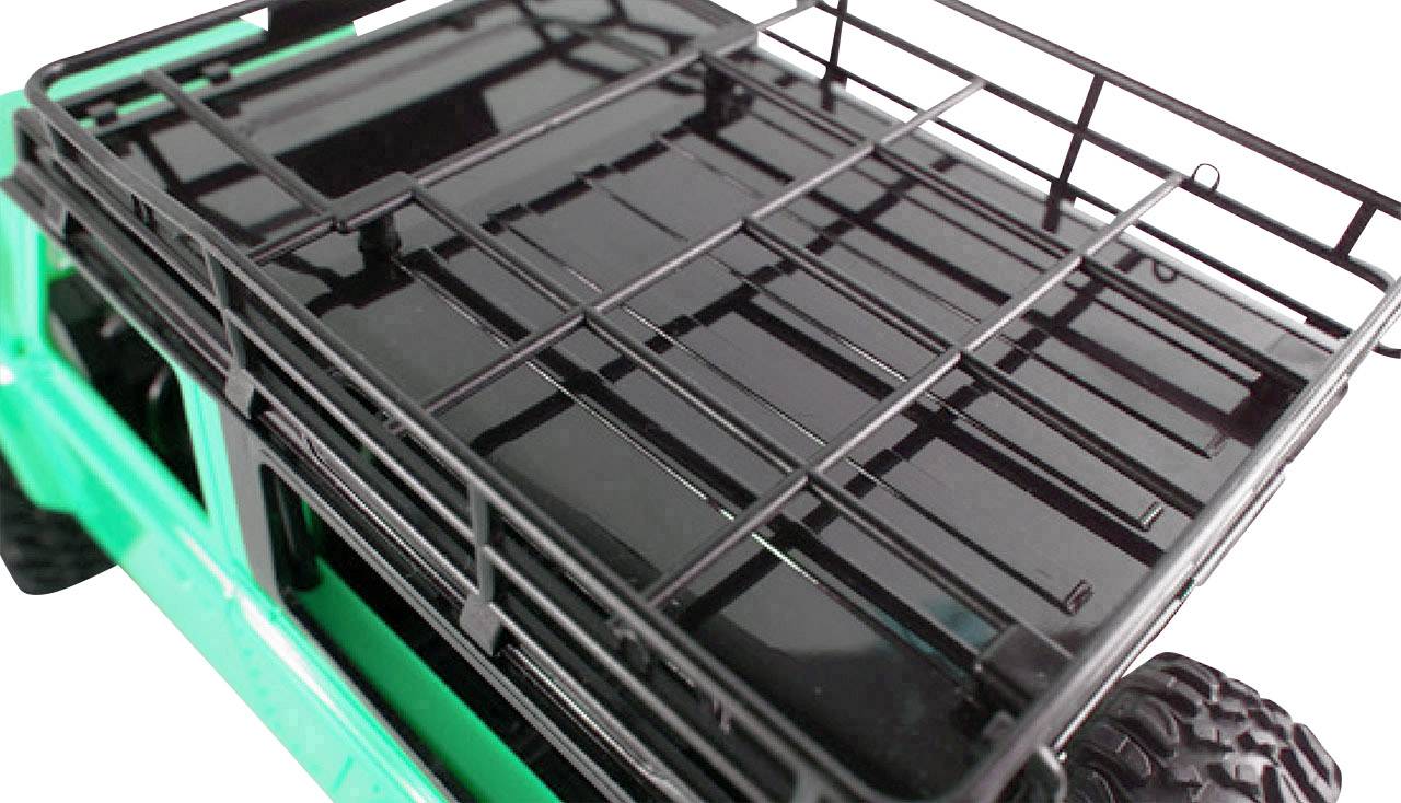 Een groene terreinwagen met een zwarte dakdrager die kan worden gebruikt voor het vervoeren van bagage of uitrusting.