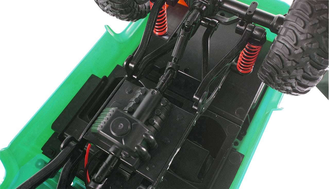 Onderkant van een bestuurbaar modelauto met een groen chassis en rode schokdempers, met focus op de ophanging en aandrijflijn.