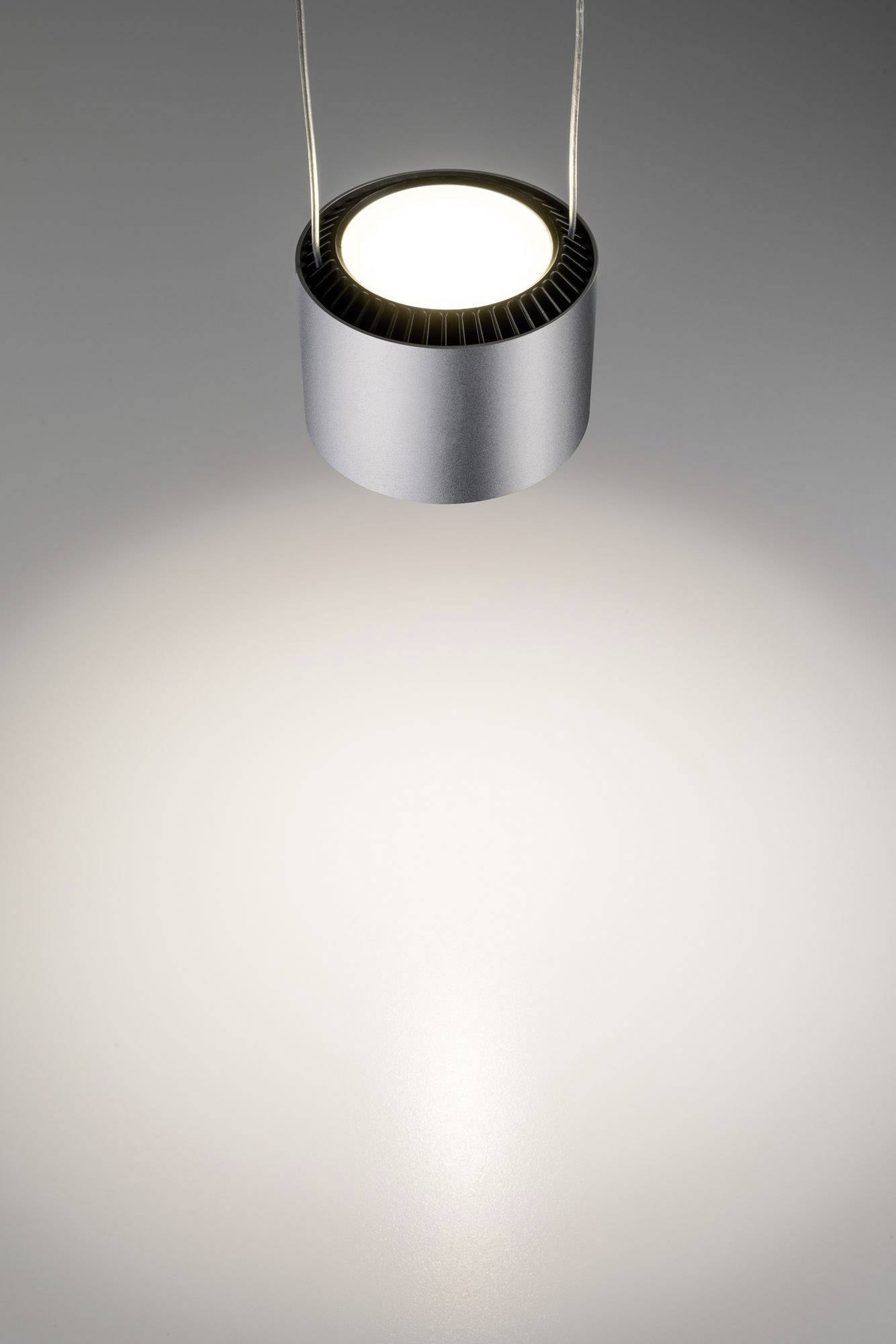 Een zilveren plafondlamp werpt een zacht licht op een grijze oppervlakte en creëert een gladde lichtkegel eronder.