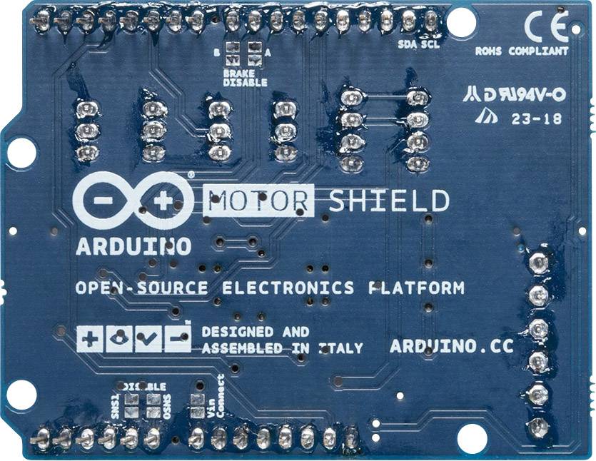 Een blauw Arduino-motorshield met labels en soldeerverbindingen, toont aansluitingen voor motorbediening en geavanceerde projecten.