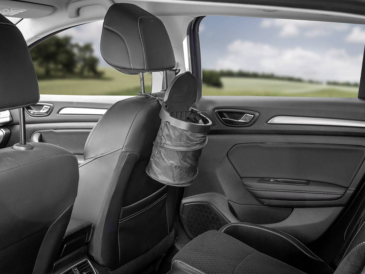 Interieur van een auto met een kleine prullenbak die aan de achterkant van de stoel is bevestigd. De prullenbak is gevouwen en ongebruikt.