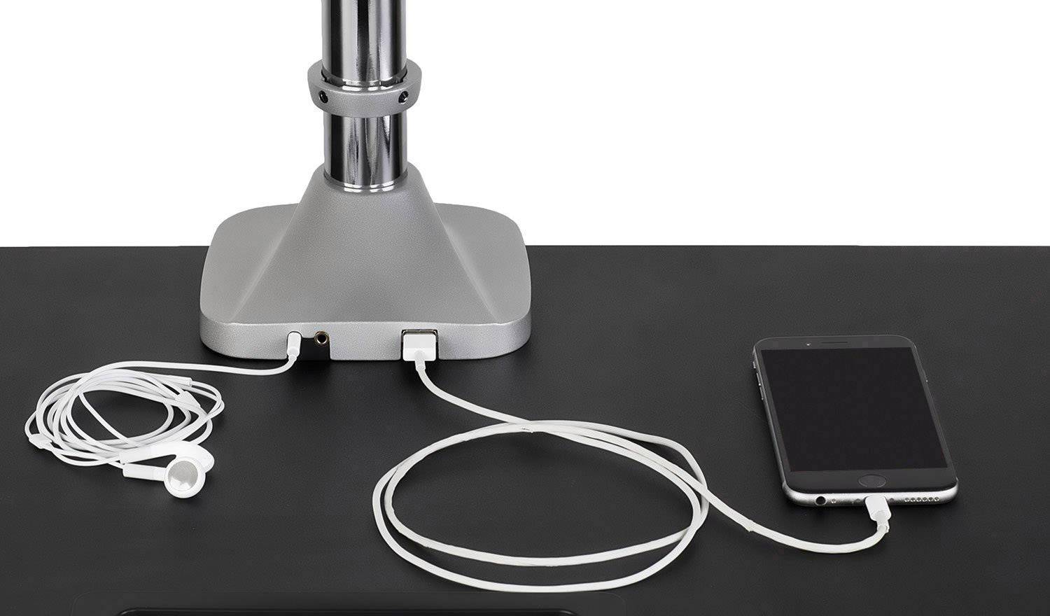 Een smartphone en koptelefoon zijn aangesloten op een stopcontact aan tafel met laadkabels.