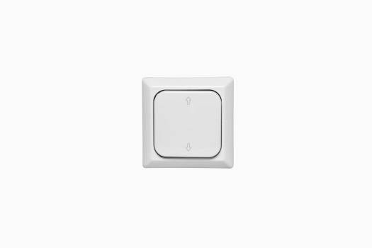 Een enkele, vierkante lichtschakelaar aan een witte muur, weergegeven in een minimalistisch design zonder zichtbare opschriften.