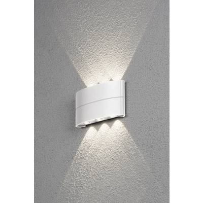 Een witte wandlamp straalt licht naar boven en beneden op een grijze muur en creëert een decoratief patroon.