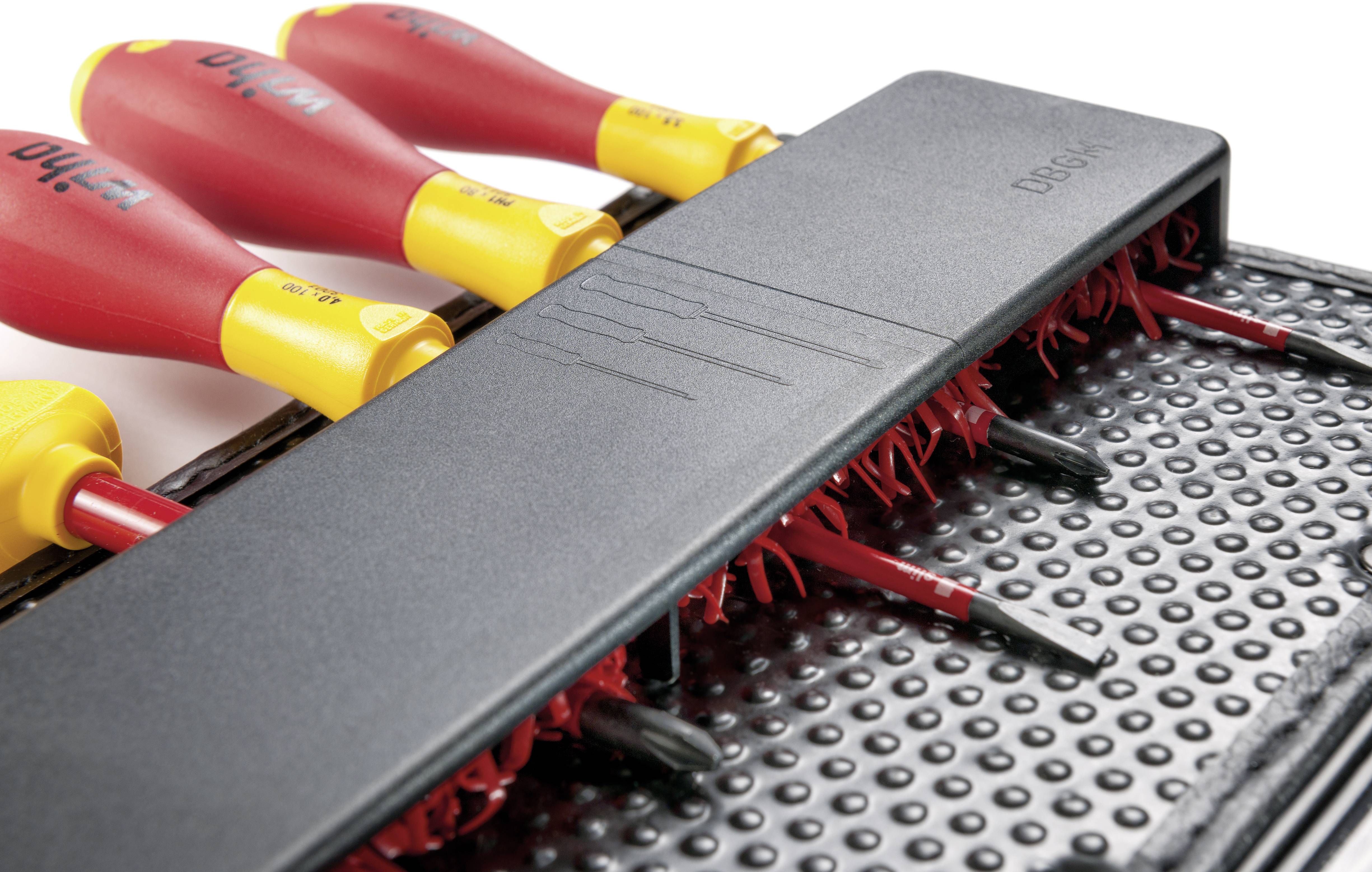 Verschillende rode schroevendraaiers met gele handgrepen, gerangschikt in een speciale houder op een gestructureerde mat.