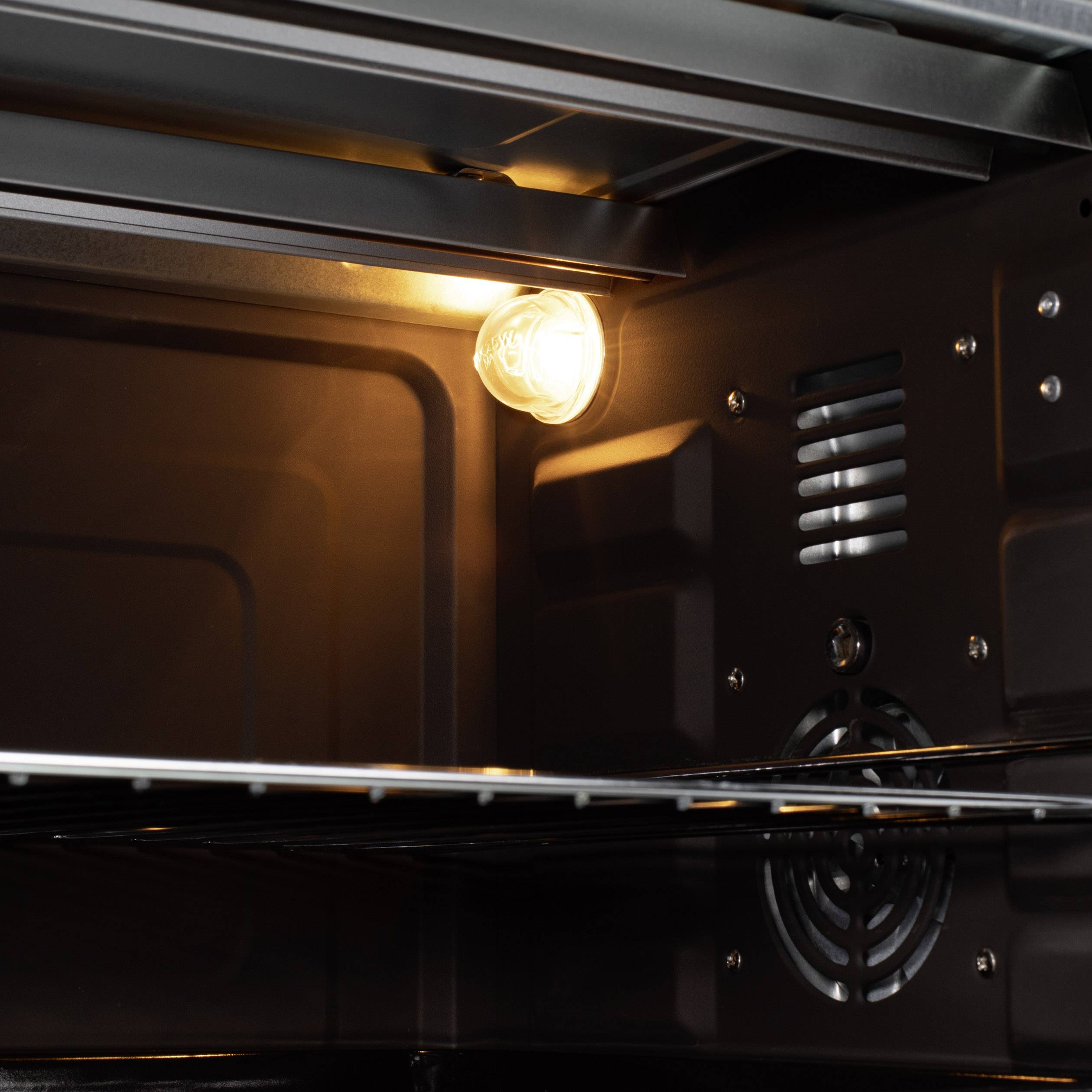 Binnenruimte van een oven met het licht aan, waarbij de lege rooster wordt verlicht. De ventilatie is zichtbaar aan de achterwand.