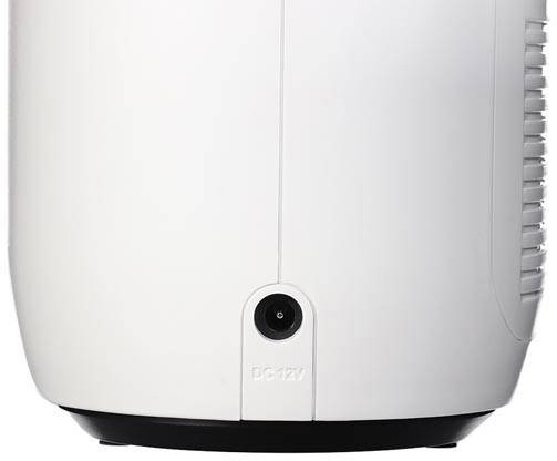 Close-up van een wit elektronisch apparaat met netaansluiting onderaan, omrand door ventilatiesleuven aan de zijkant.