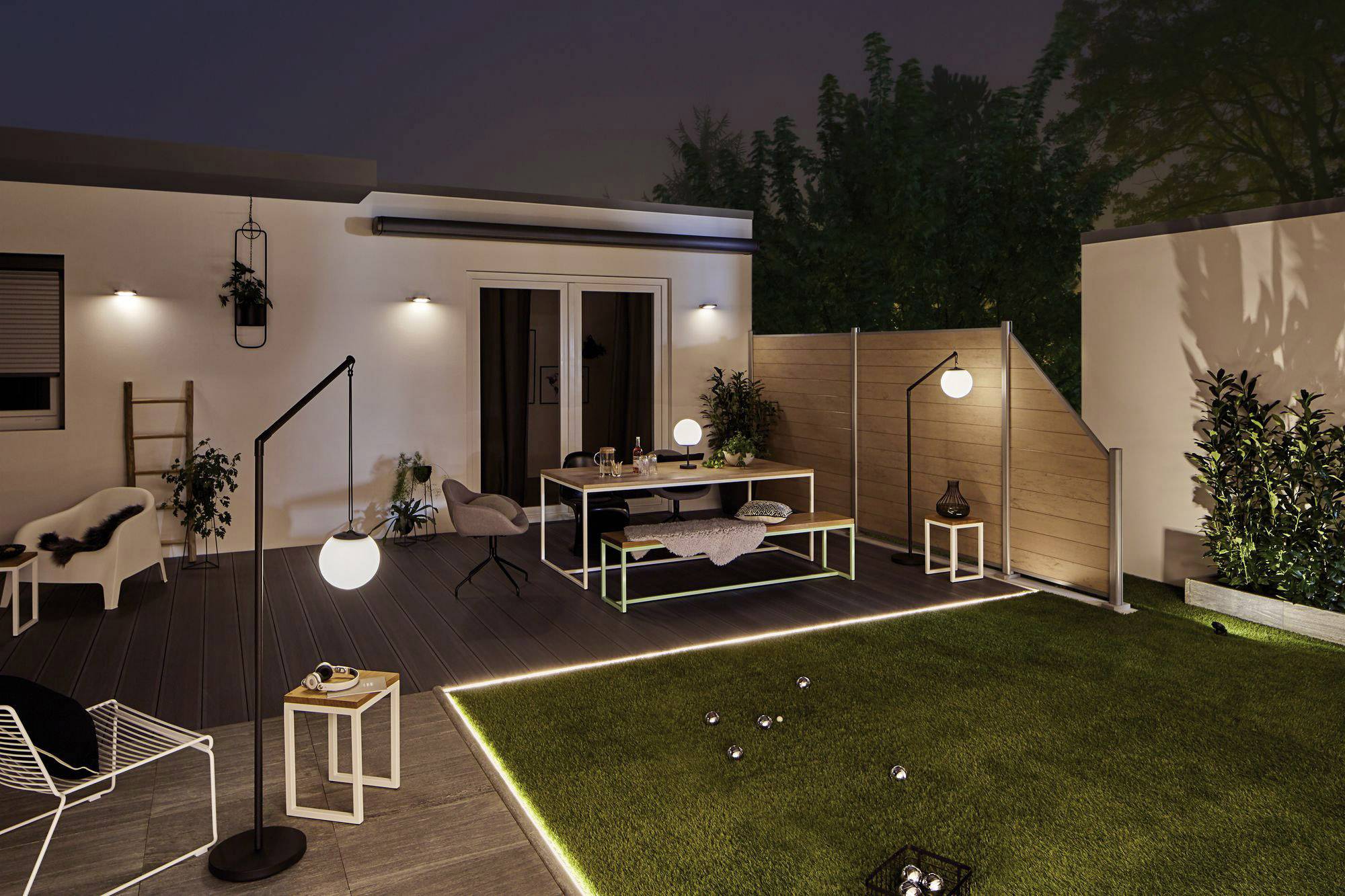 Moderne terras bij nacht met stijlvolle meubels, sfeervolle verlichting en goed onderhouden gazon. Perfect voor ontspannen avonden.