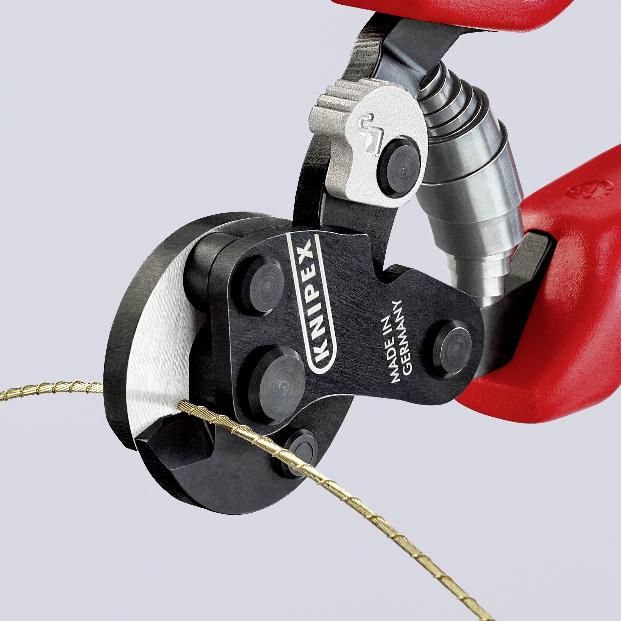 Knipex-zijkniptang met rode handgreep knipt een draad door. Gereedschap in close-up, vervaardigd in Duitsland.