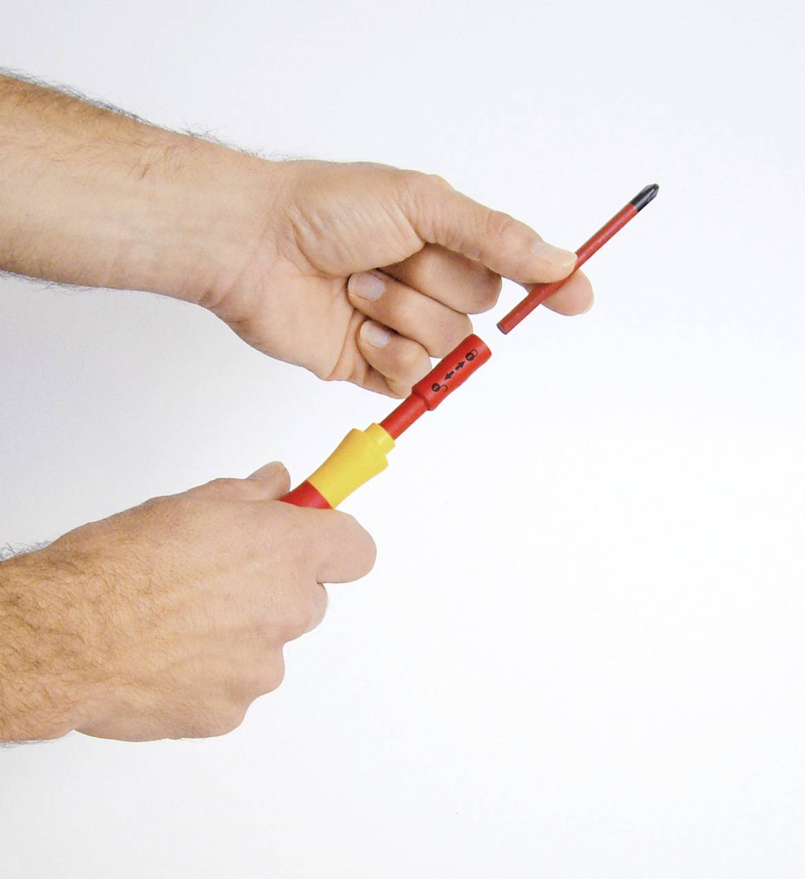 'Een persoon houdt een geïsoleerde schroevendraaier vast met beide handen, klaar voor gebruik.'