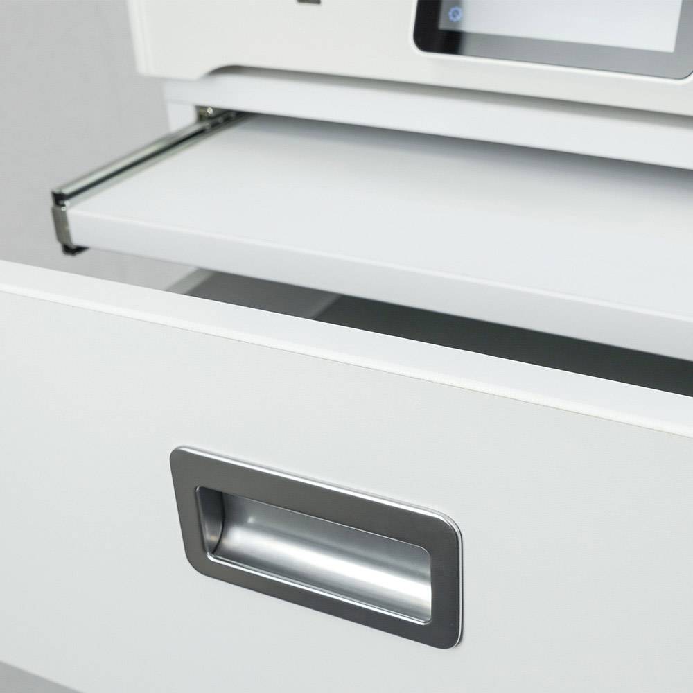 Een open printerlade van een witte printer met een uitgetrokken papierlade, zichtbaar in een kantooromgeving.