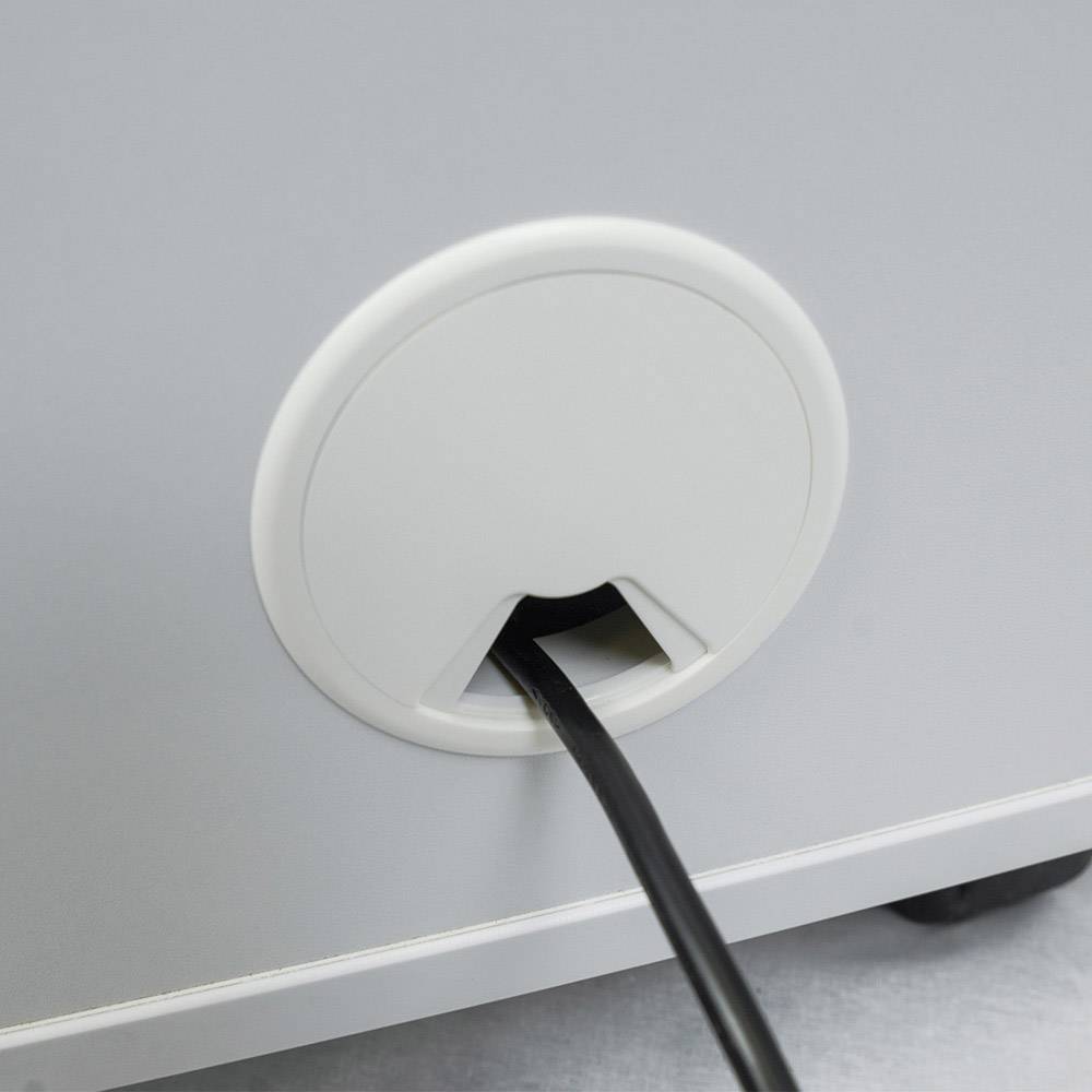 Zwart kabel steekt door een rond gat aan de achterkant van een grijs meubel.