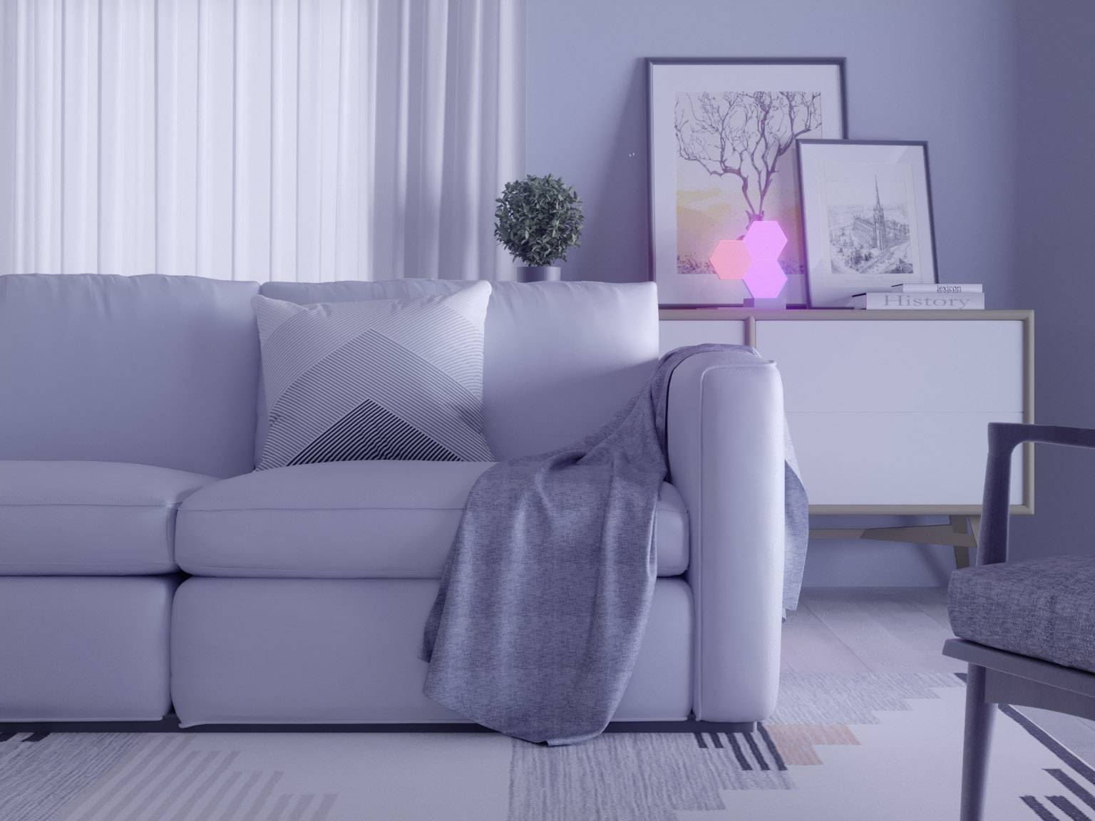 Een modern woonkamer met een witte bank, een grijze plaid en kussens, op de achtergrond een dressoir met kunstwerken.