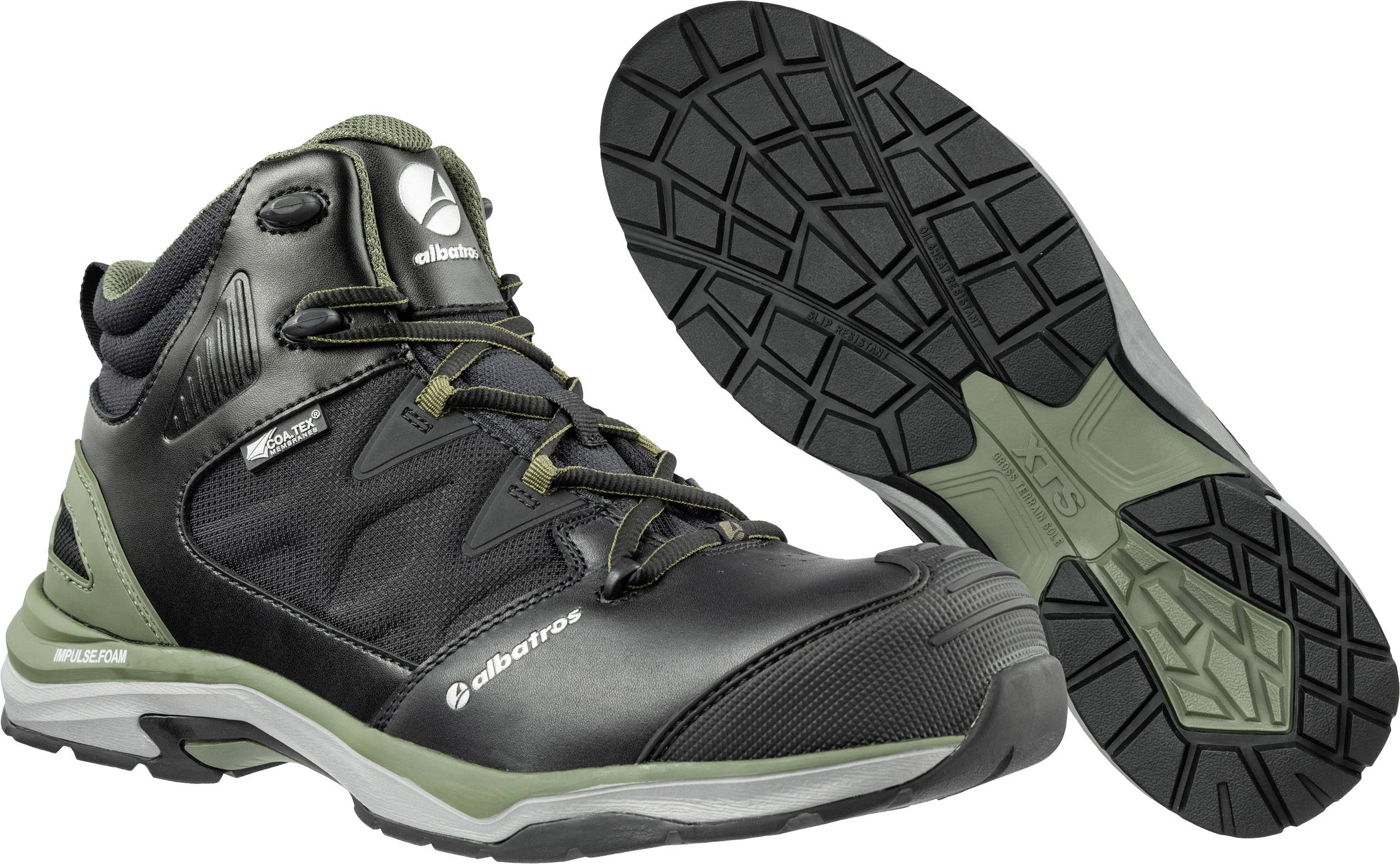 Zwarte trekkingschoenen met groene accenten en een lichte zool, geschikt voor buitenactiviteiten. Merknaam zichtbaar aan de zijkant.