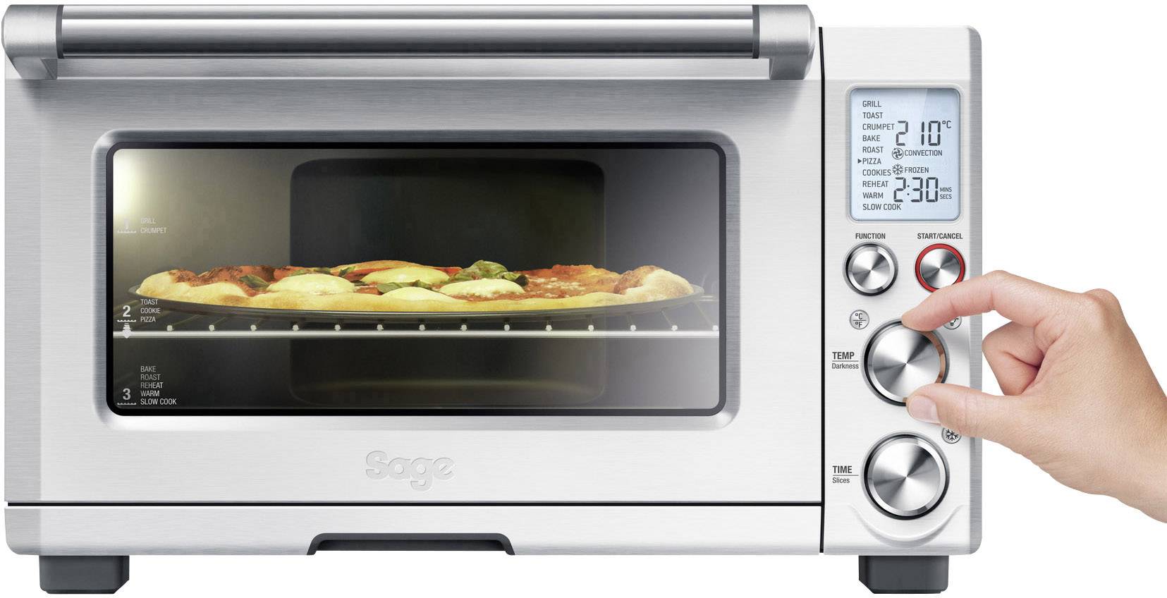 Een zilveren broodrooster met een digitaal display toont de temperatuur. Er wordt momenteel een pizza gebakken. Een hand bedient de instelknop.