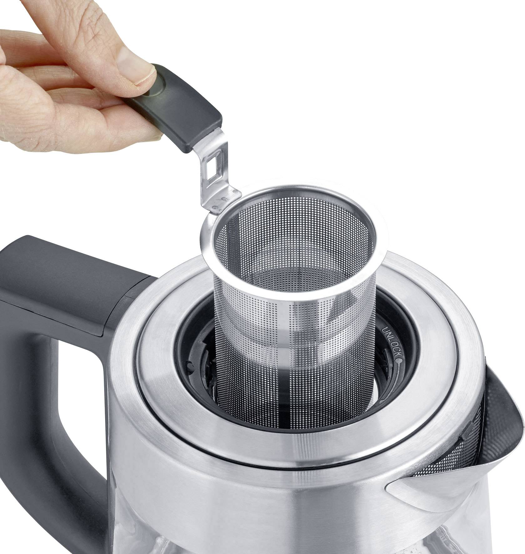 Een hand tilt de theezeef uit een moderne theepot van roestvrij staal.