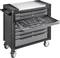 Een zwarte gereedschapswagen met vier laden, waarvan er één open is en verschillende gereedschappen zoals schroevendraaiers laat zien.