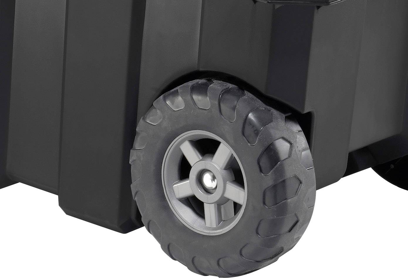 Een robuust zwart wiel aan een grotere container of koffer, ontworpen voor mobiliteit en transport over oneffen oppervlakken.