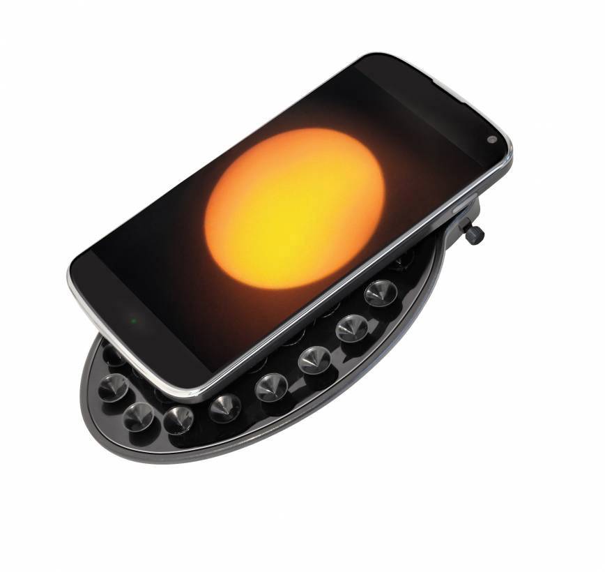 Een smartphone met een fel oranje zonnescherm ligt op een ovaal, knopvormig object.