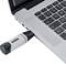 Een USB-stick is in een laptop gestoken. De laptop heeft een zilveren toetsenbord met zwarte toetsen.