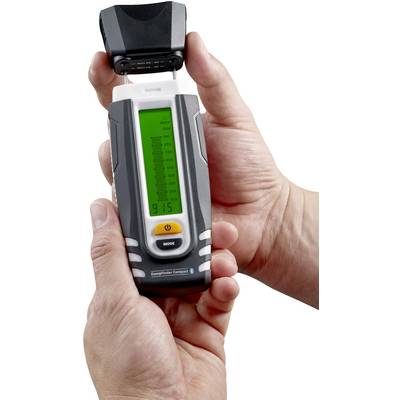 Een persoon houdt een draagbaar meetapparaat vast met een groen display dat gegevens weergeeft. Het apparaat heeft een modusknop en een beschermende afdekking.