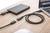Externe harde schijf aangesloten op een laptop op een houten tafel; USB-kabel en adapter zijn zichtbaar.