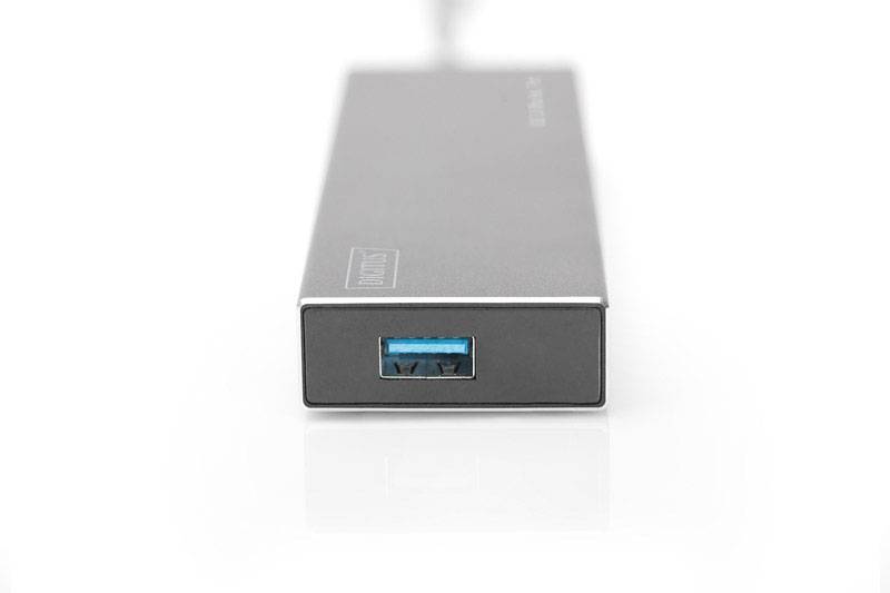 Een zilveren USB-oplader ligt op een gladde witte oppervlakte. Het heeft een blauwe USB-aansluiting aan de voorkant.