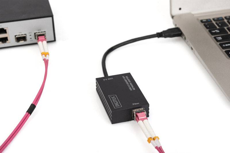 Een converter verbindt een laptop met een netwerktoestel. Een glasvezelkabel loopt naar de laptop, terwijl een Ethernet-kabel het netwerktoestel aansluit.
