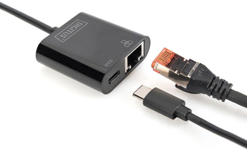 Een zwarte adapter met Ethernet- en USB-C-poorten naast een netwerkkabel en een USB-C-kabel, klaar om verbinding te maken.