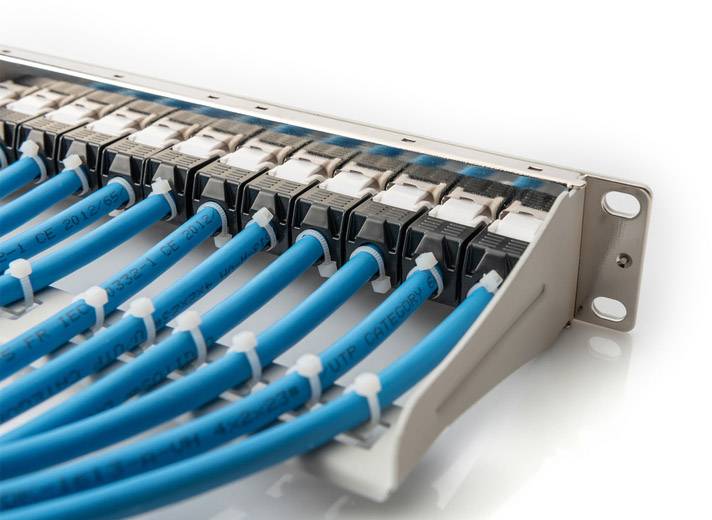 Een patchpanel met meerdere aangesloten blauwe netwerkkabels in een serveromgeving.