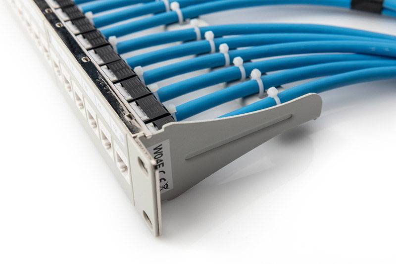 Blauw netwerkkabelsysteem verbonden met een patchpanel in een serverruimte, toont netwerkhardware en -infrastructuur.