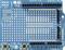 Een blauw Arduino-shield met verschillende aansluitingsmogelijkheden voor digitale en analoge in-/uitgangen, schakelaars en LED's.