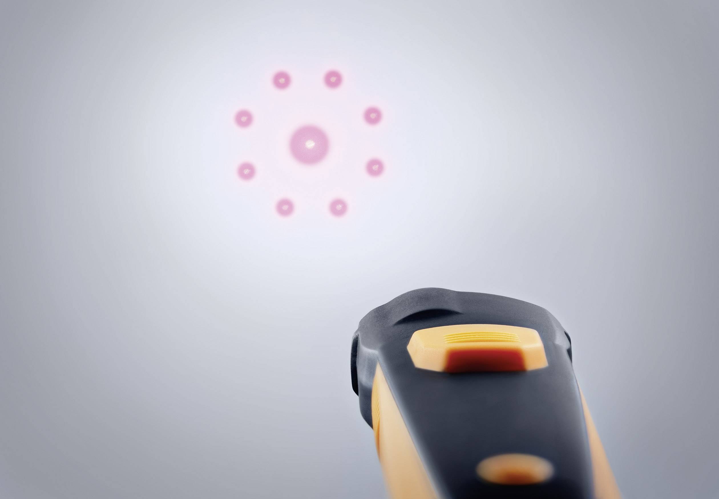 Een infrarood-thermometer toont rode laserpunten in een cirkel. Het wordt gebruikt om de temperatuur van een oppervlak te meten.
