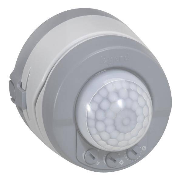 Een ronde bewegingsdetector met een grijs en wit behuizing, meerdere schakelaars en een grote, centrale sensor in het midden.