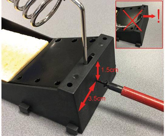 Soldeerbouthouder met schroevendraaier toont hoe een schroef wordt verwijderd. Rode 'X' in de uitsnede toont de verkeerde opstelling.
