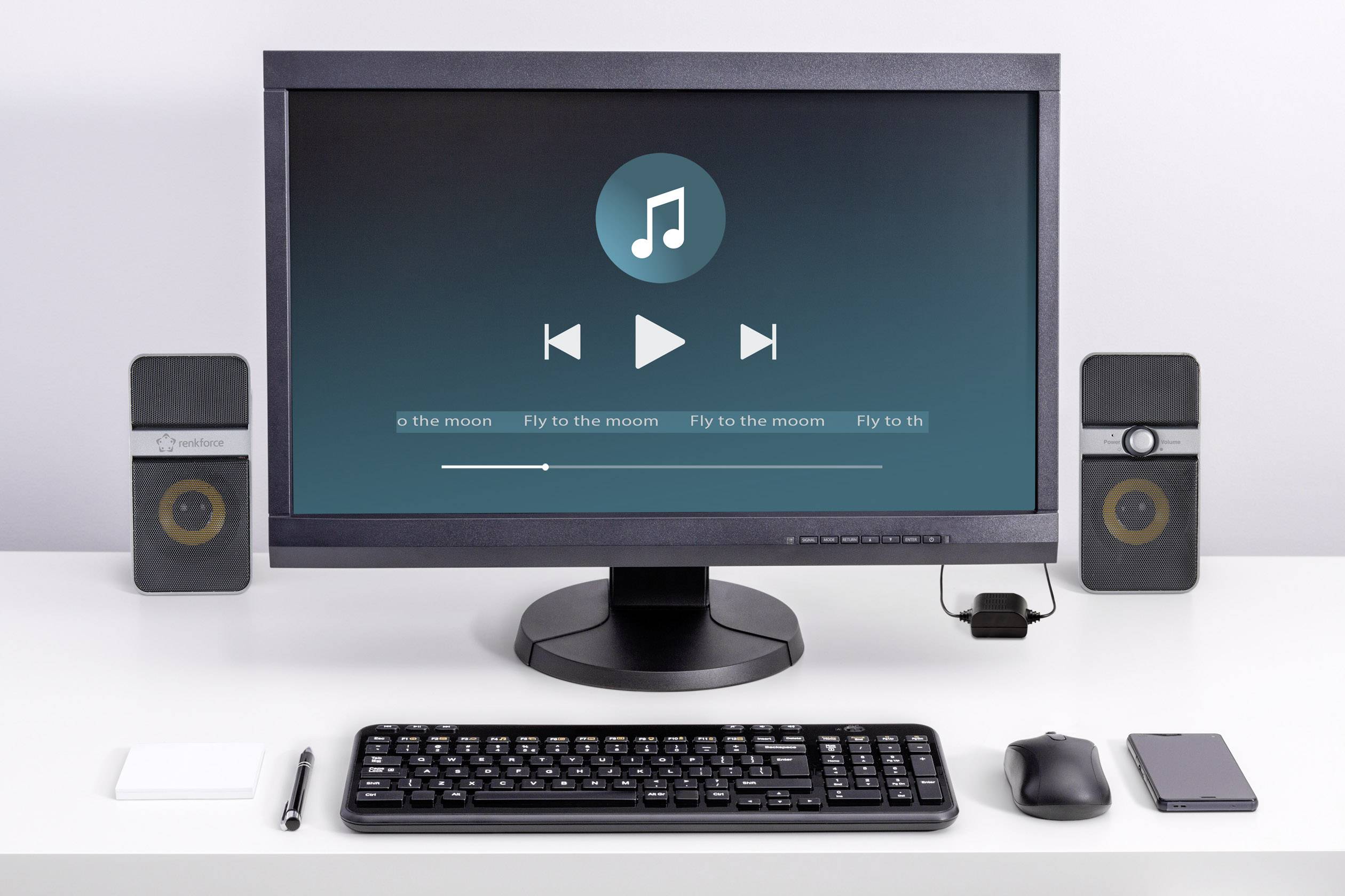 Een computerscherm toont een muziekspeler met afspeelbesturing en het nummer 'Fly to the moon'. Ernaast speakers.