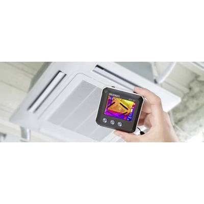 Een hand houdt een warmtebeeldcamera vast die de verwarmingscapaciteit van een airconditioning toont.
