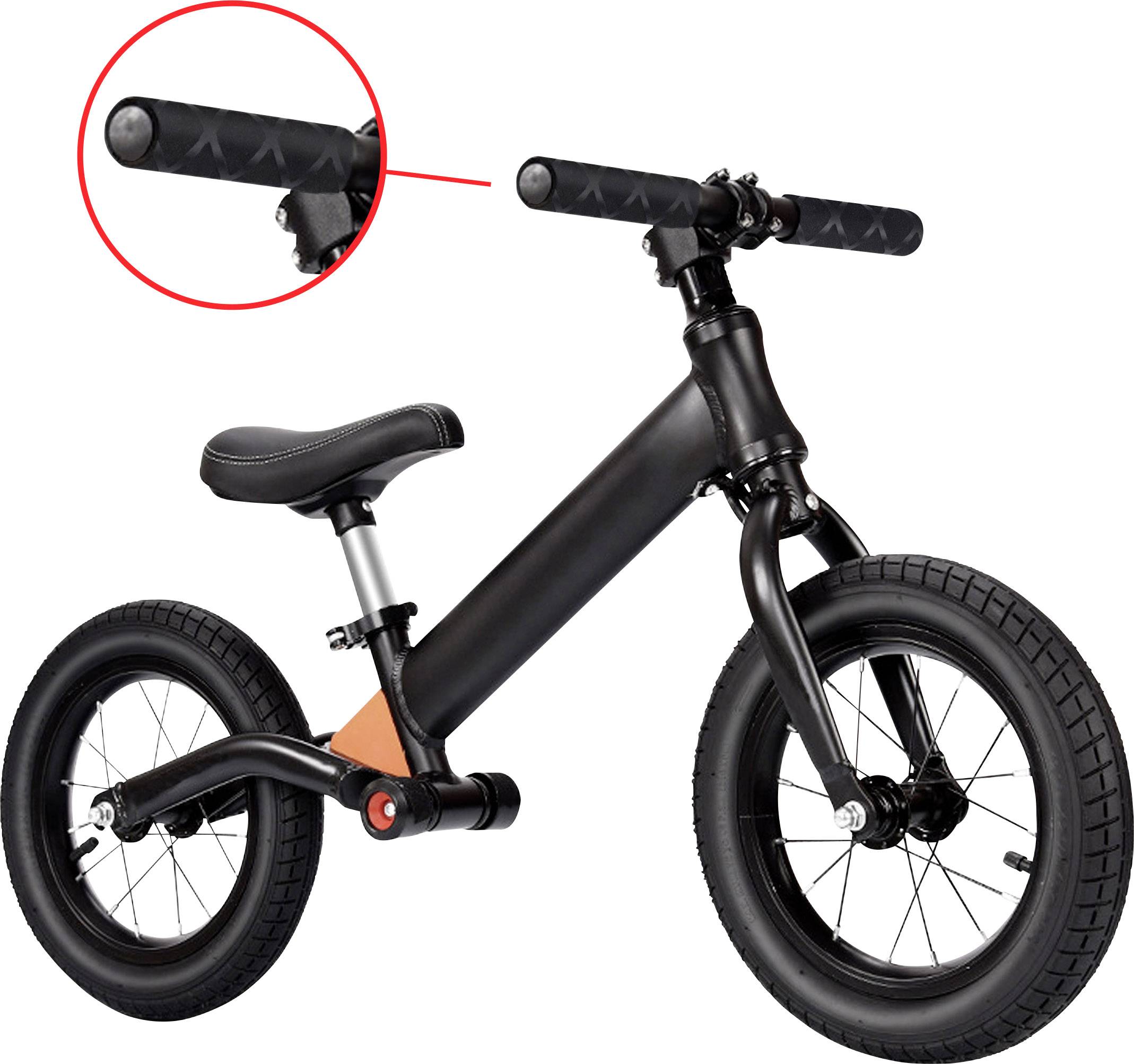Een zwarte loopfiets met zadel en handvatten wordt getoond. Een rode cirkel benadrukt de linkerkant van het handvat. De achtergrond is wit.