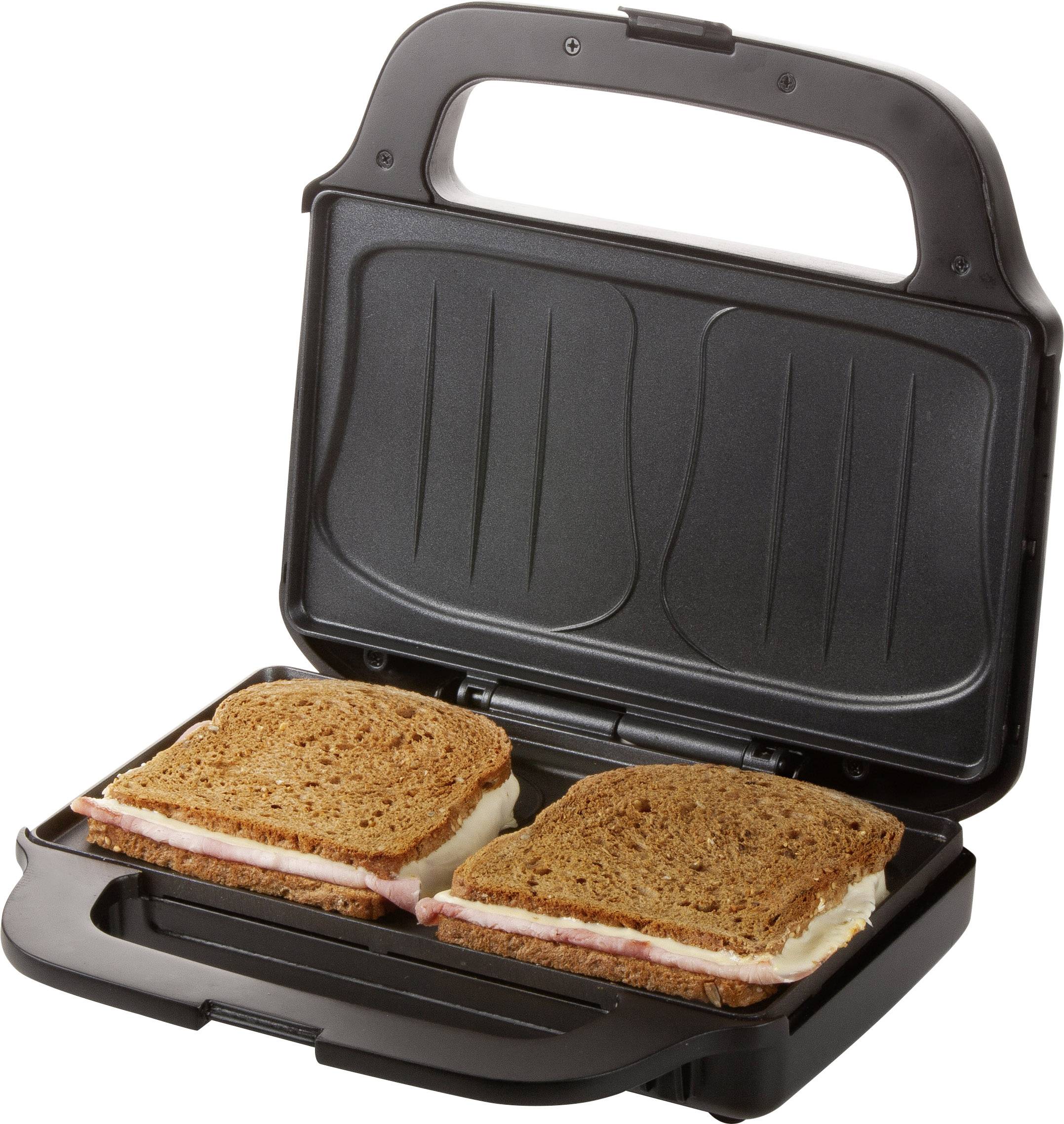 Een tosti-ijzer met twee gesloten tostisandwiches van donker brood, gevuld met ham en kaas, klaar om te grillen.