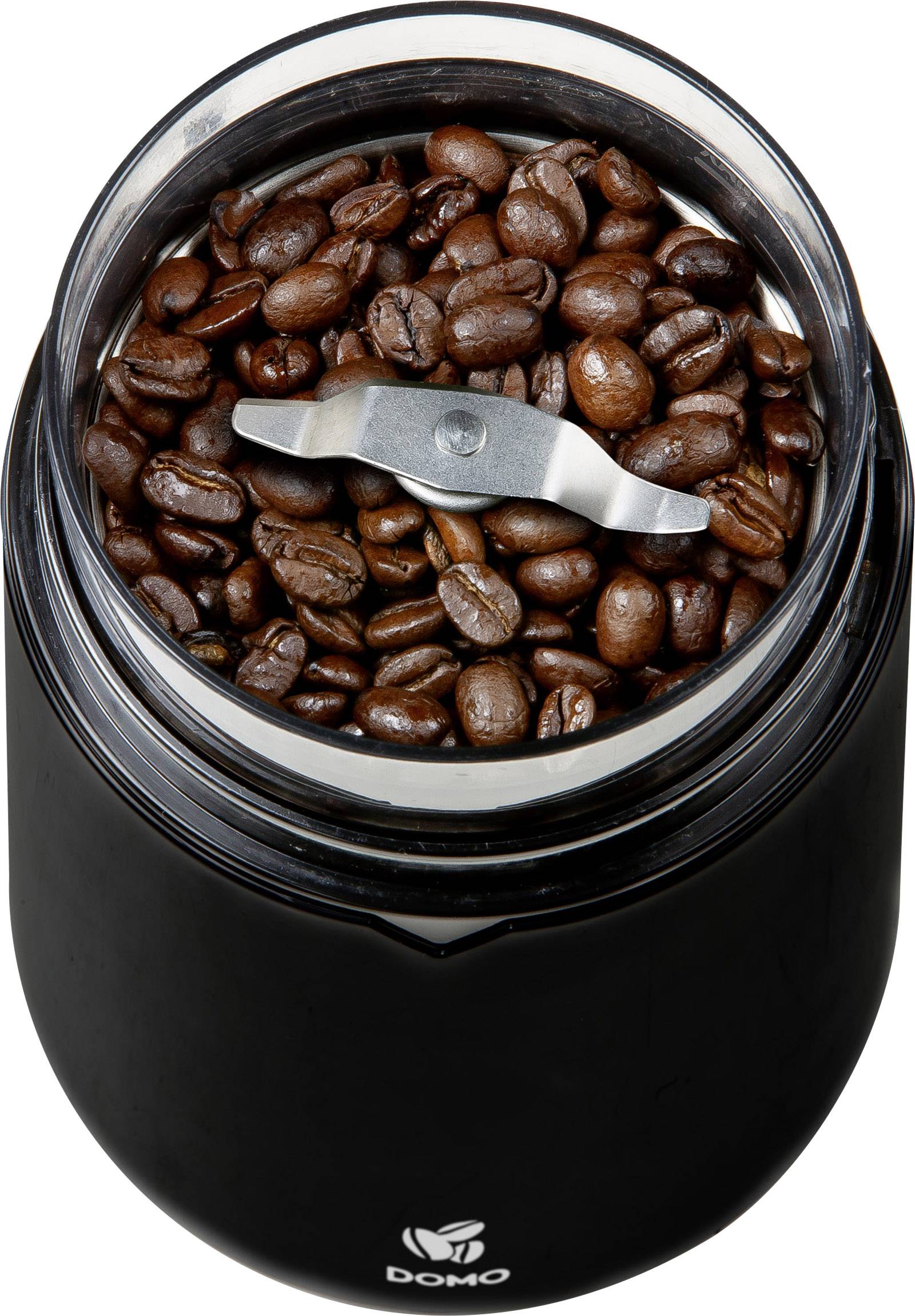 Koffiemolen met open deksel, gevuld met vers gebrande koffiebonen. Het snijmes is zichtbaar.