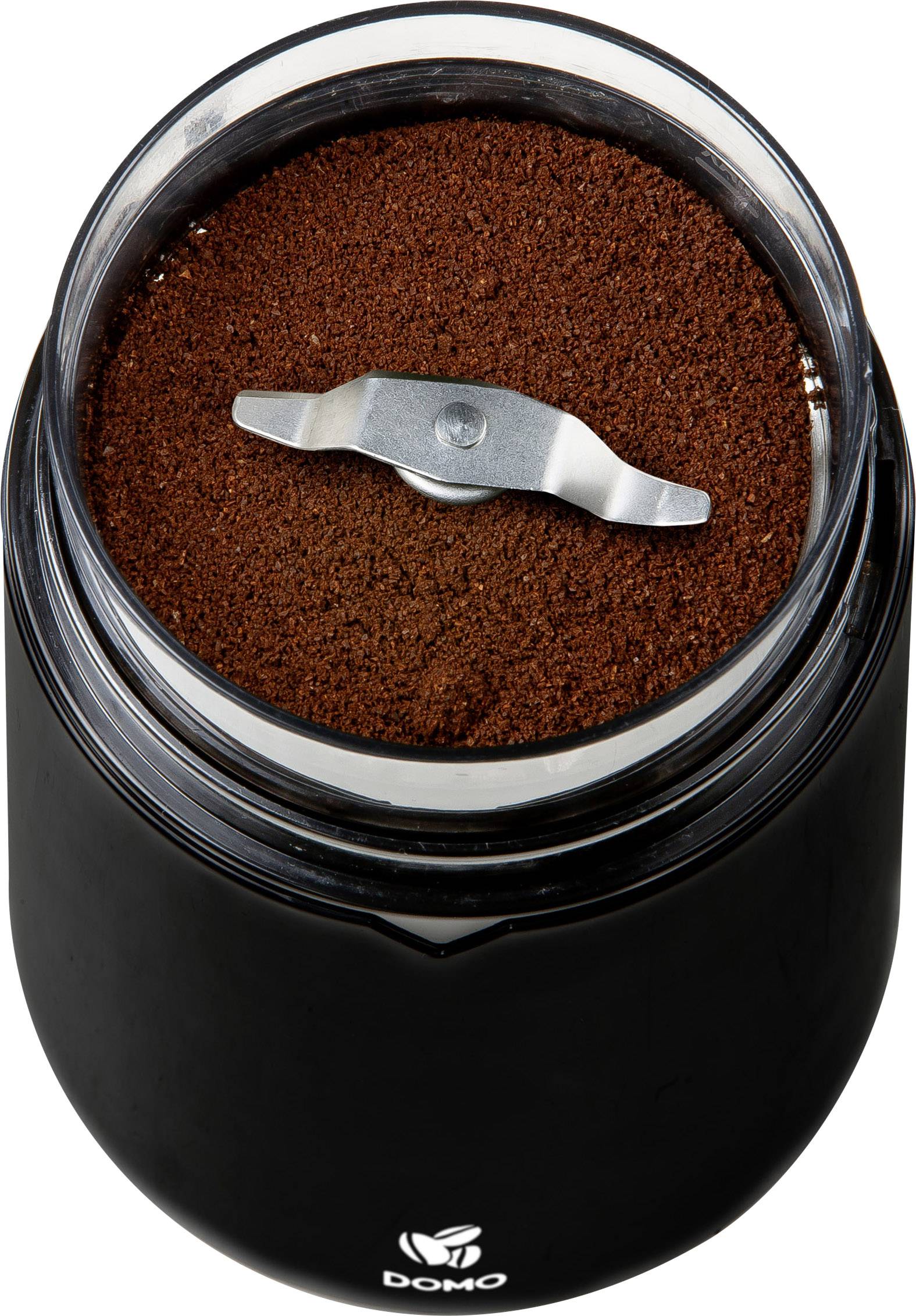 Zwarte koffiemolen met roestvrijstalen mes, gevuld met gemalen koffie, bekeken van bovenaf.