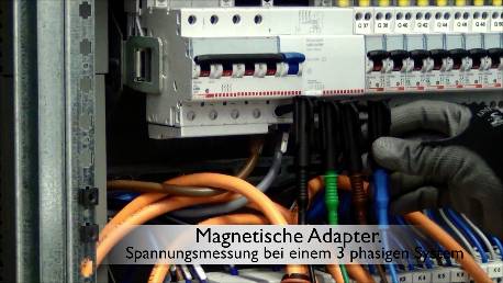 Een elektricien meet de spanning in een driefasig systeem met magnetische adapters. Verschillende gekleurde kabels zijn zichtbaar.